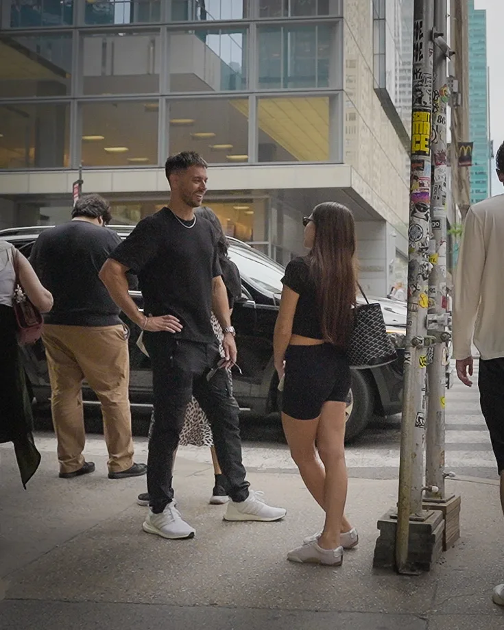 Matt talking with a woman who has stopped on the sidewalk.