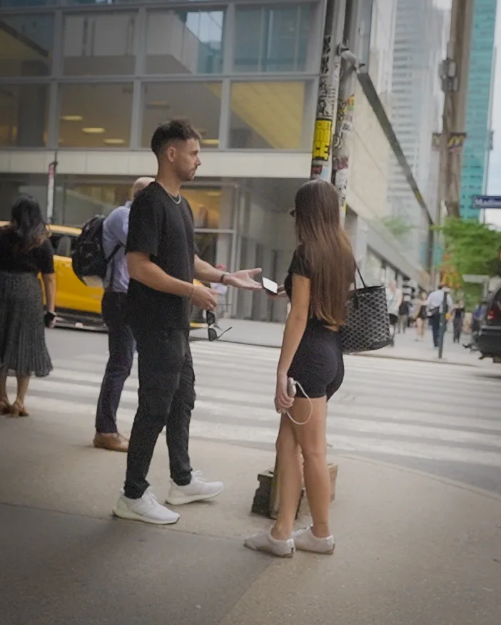 Matt handing his phone over to the same woman to take her number.